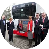 Führungspersonal von Engagement Global, dem BMZ sowie die damalige Ministerin für Bundesangelegenheiten, Europa und Medien des Landes Nordrhein-Westfalen, Angelica Schwall-Düren, stehen vor einem Bus mit Engagement Global Werbung.