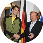 Minister Niebel schüttelt dem Freiwilligen Christian Päßler die Hand.